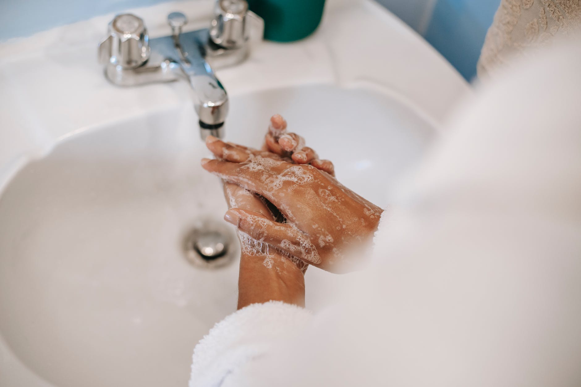 faceless ethnic woman washing hands in washstand